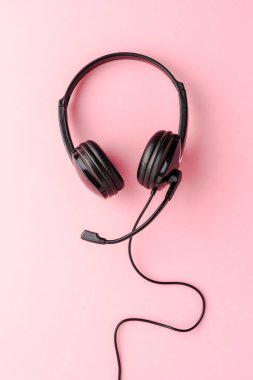Pembe arka planda, kopyalanmış kulaklıklar.