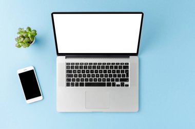 Bilgisayarlı, boş ekranlı ve mavi masadaki cep telefonlu iş geçmişi. Ofis masaüstü. Üst görünüm