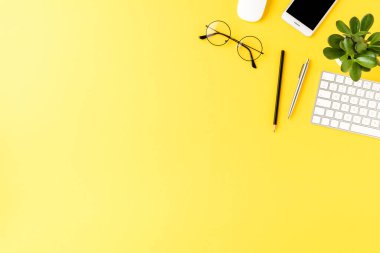 İş aksesuarlarının telif alanlı sarı arka planda çekimleri. Ofis masaüstü