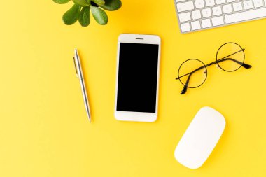 İş geçmişi, cep telefonu ve sarı masadaki boş ekran. Aksesuarlı ofis masaüstü