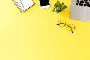 İş aksesuarlarının telif alanlı sarı arka planda çekimleri. Ofis masaüstü