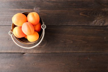 Arka planda metal kasede kayısılar var. Üst görünüm