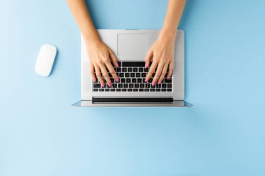 Mavi masada dizüstü bilgisayar kullanan kadınların el resimleri. Ofis masaüstü. Düz yatıyordu