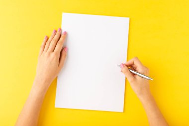 Boş beyaz kağıda yazı yazan kadın eli resmi. Kapat.