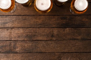 Kopyalama alanı olan ahşap masada bira bardakları.