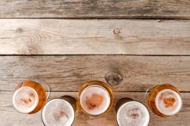 Ahşap masanın üstünde bira bardakları..