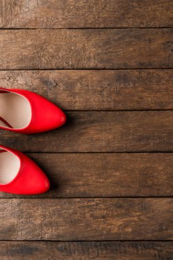 Zarif kadın ayakkabıları. Tahta arka planda kırmızı yüksek topuklu ve kopyasal alan