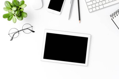 İş aksesuarlarıyla beyaz arkaplanda izole edilmiş boş ekranlı dijital tablet. Ofis masaüstü