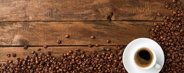 Black coffee cup with beans on retro wooden background with copyspace. Top view. Banner clipart