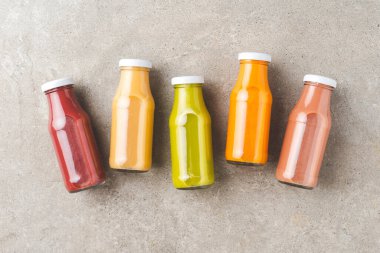 Taş masada renkli meyve suları. Şişede taze meyve püresi