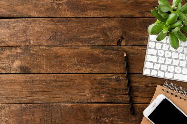 Bilgisayarlı klavyesi, akıllı telefonu, defteri, kalemi ve yeşil bitkisi olan bir ofis masası. İş geçmişi