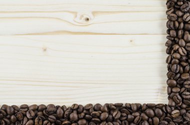 Kahve çekirdekleri ahşap masa üzerinde çerçeve. Arka plan