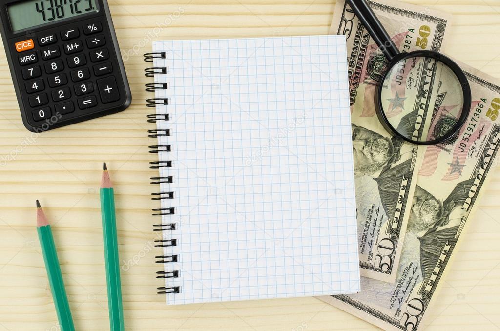 Office, business tools with notebook and dollars on wooden table