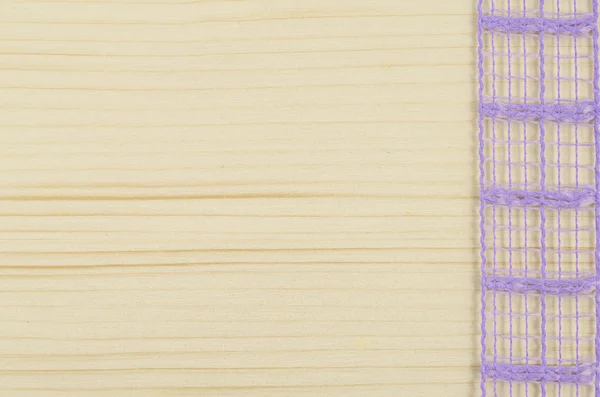 Ramka fioletowy wstążki na drewnianym stole — Zdjęcie stockowe