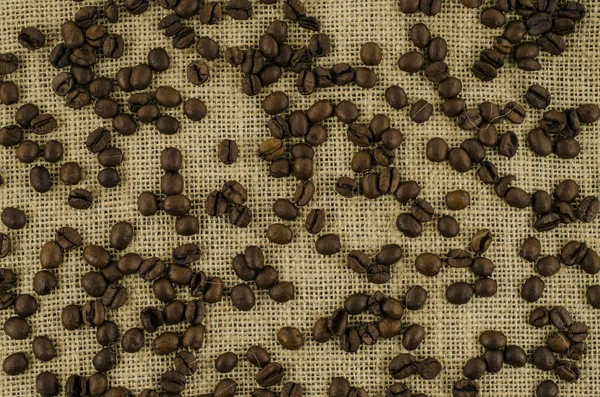 Grãos de café em fundo de linho — Fotografia de Stock
