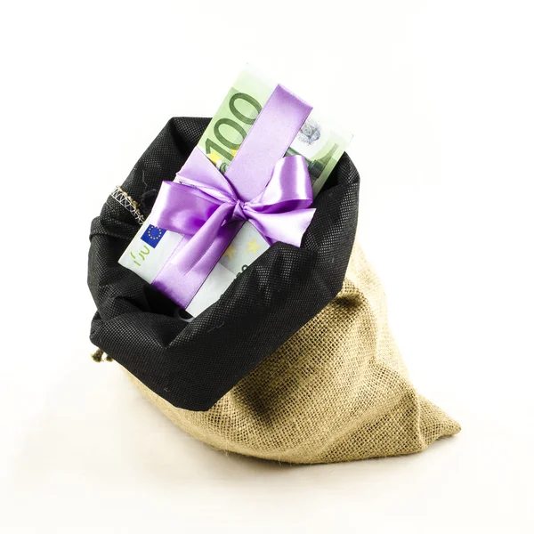 Dinero con lazo rosa en bolsa de yute — Foto de Stock