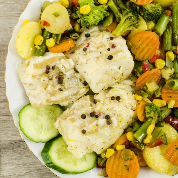 Cod fish on plate with vegetables — Stock Photo, Image
