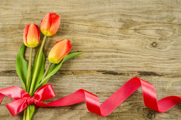 Fundo de madeira vazio com flores coloridas e fita vermelha — Fotografia de Stock