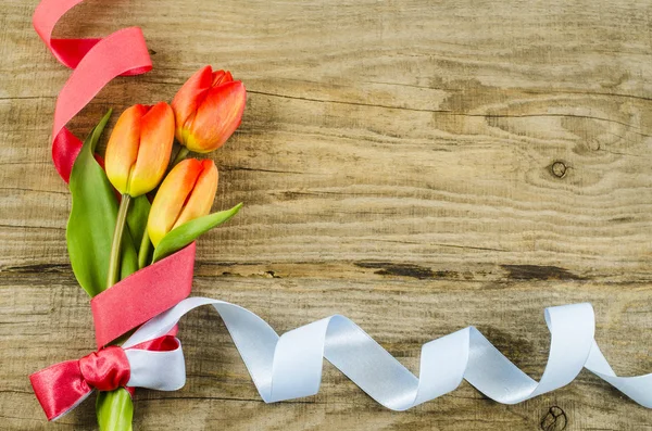 Fond en bois vide avec des fleurs colorées et un ruban — Photo