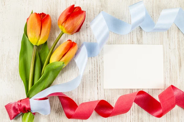 Empty postcard, colorful flowers and ribbon on wooden background — Stock Photo, Image