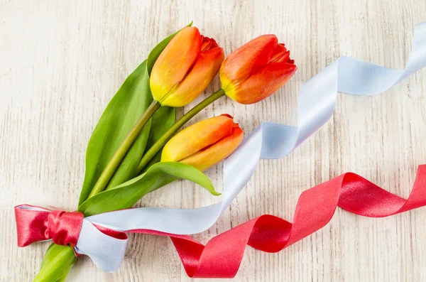 Empty wooden background with colorful flowers and blue ribbon — Stock Photo, Image
