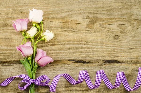 Empty wooden background with colorful flowers and purple ribbon — Stock Photo, Image