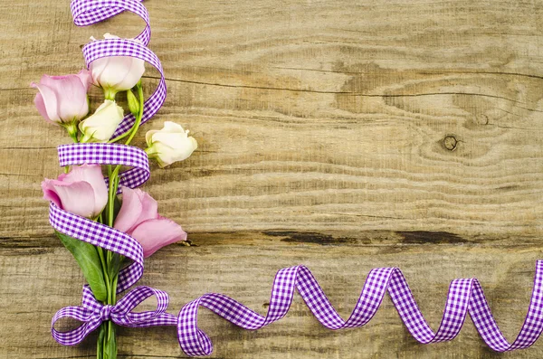 Empty wooden background with colorful flowers and purple ribbon — Stock Photo, Image