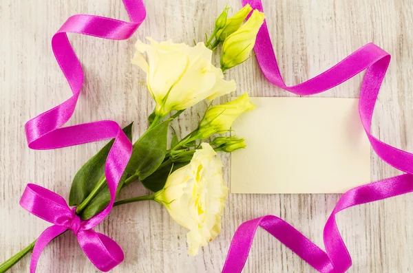 Cartolina vuota, fiori colorati e nastro su sfondo di legno — Foto Stock
