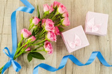 Gül çiçeği ve hediye kutusu ahşap arka planda