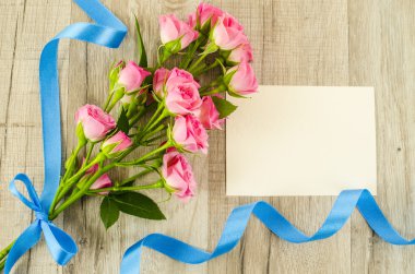 Boş kartpostal, çiçek ve ahşap zemin üzerine mavi şerit
