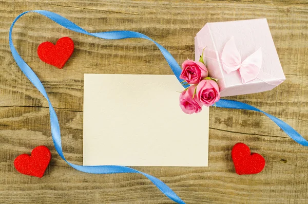 Postal vacía con flor de rosa, caja de regalo, corazón y cinta — Foto de Stock