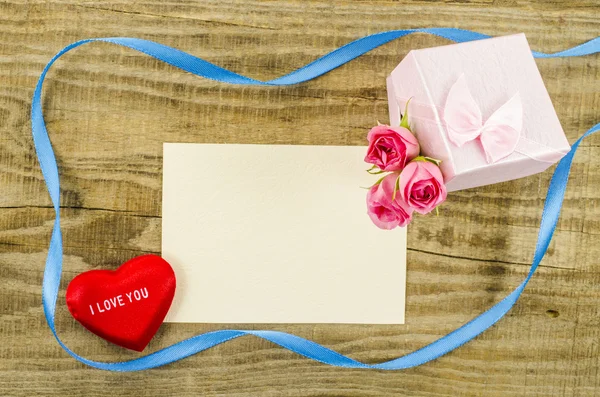 Empty postcard with rose flower, gift box, heart and ribbon — Stock Photo, Image