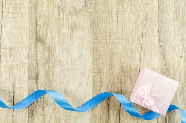 Gift box and ribbon on wooden background — Stock Photo, Image