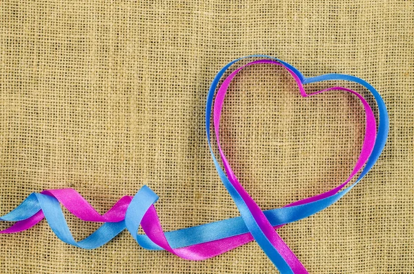 Heart shaped ribbon on linen background — Stock Photo, Image