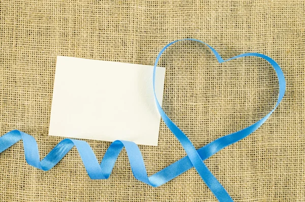 Prázdná karta se srdcem ve tvaru pásu na lněné pozadí — Stock fotografie