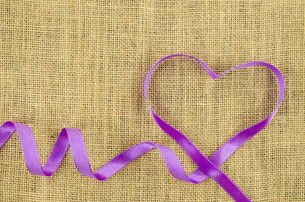 Heart shaped ribbon on linen background — Stock Photo, Image