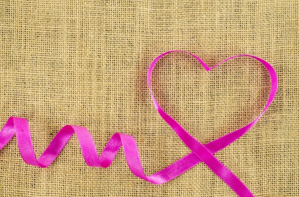 Heart shaped ribbon on linen background — Stock Photo, Image