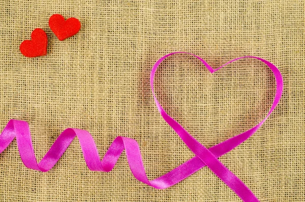 Heart shaped ribbon on linen background — Stock Photo, Image