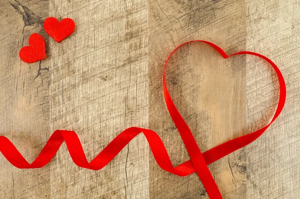 Καρδιά σχήμα κορδέλα σε ξύλινα φόντο — Φωτογραφία Αρχείου