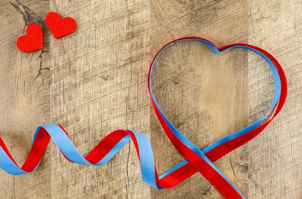 Heart shaped ribbon on wooden background — Stock Photo, Image