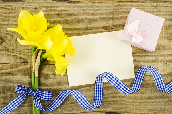 Carta vuota con fiore e nastro su sfondo di legno — Foto Stock