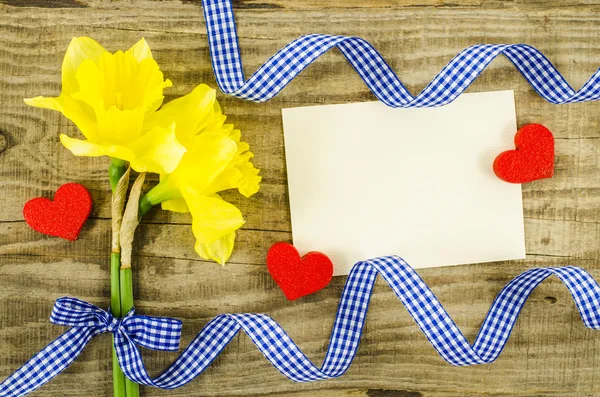 Carta vuota con fiore e nastro su sfondo di legno — Foto Stock