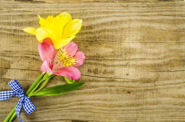 Flower with blue ribbon on wooden table — Stock Photo, Image