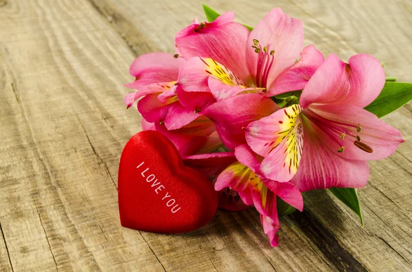 Bouquet de fleurs roses avec coeur sur table en bois — Photo