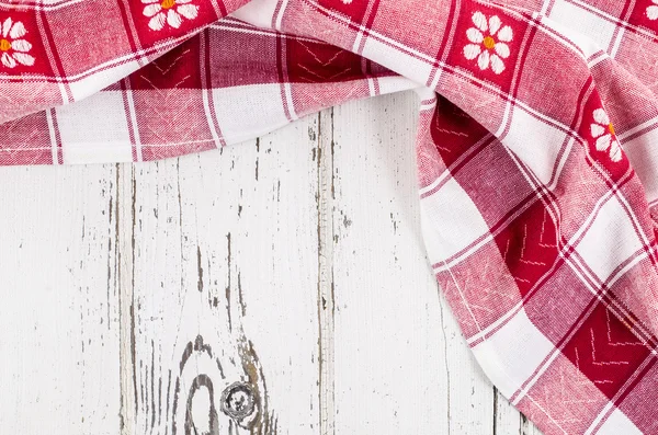 Red folded tablecloth over wooden table — Stock Photo, Image