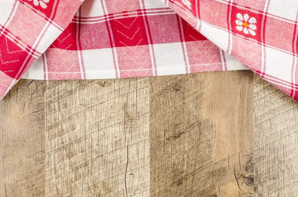 Red folded tablecloth over wooden table — Stock Photo, Image