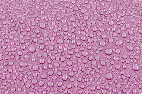 Roze water druppels achtergrond of textuur. Close-up — Stockfoto