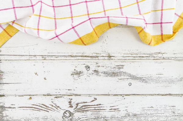 Žlutá složený ubrus dřevěný stůl — Stock fotografie