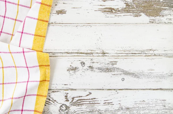 Mantel doblado amarillo sobre mesa de madera — Foto de Stock
