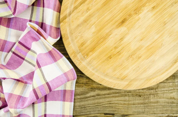 Folded towel with wooden board over wooden table — Stock Photo, Image